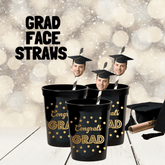 congrats grad cups with straws featuring a mans face wearing a graduation cap displayed on a table